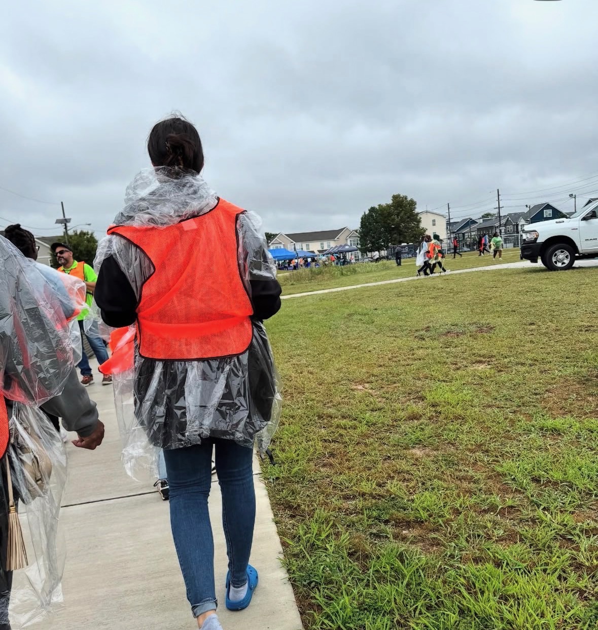 Volunteers in safety vests and rain ponchos heading out with supplies