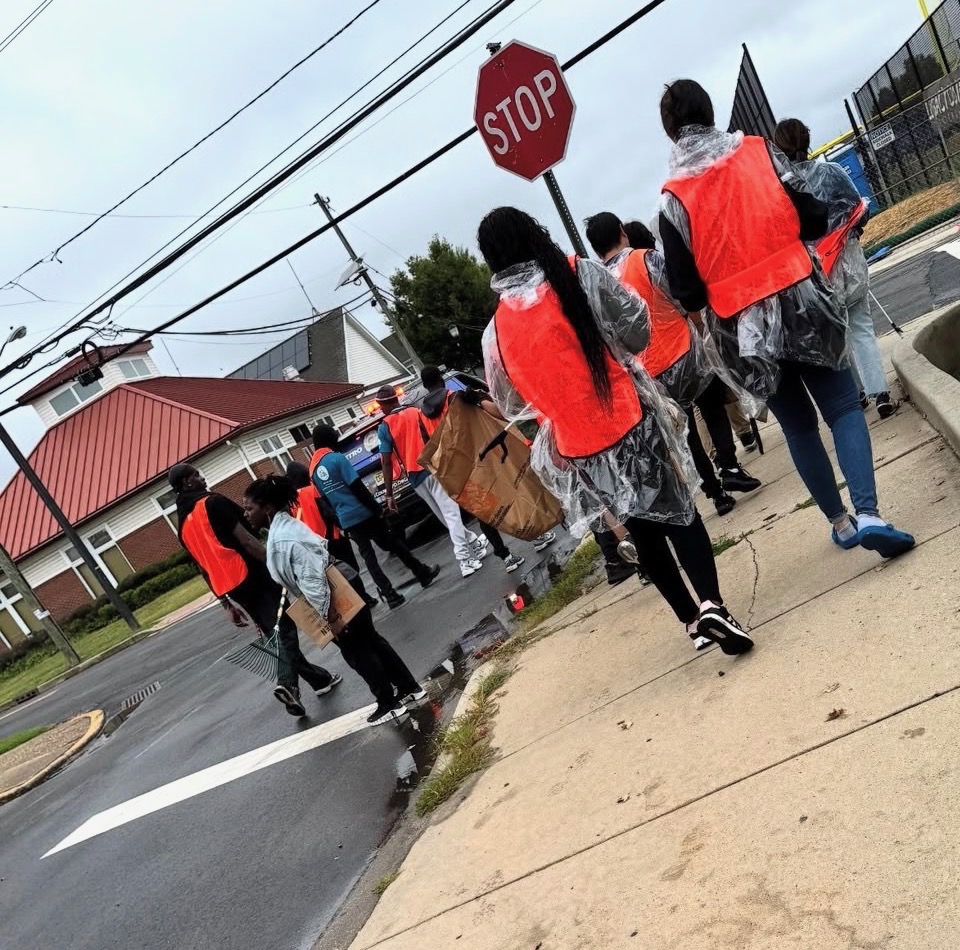 Cleanup crew crossing the street with rakes, brooms and collection bags