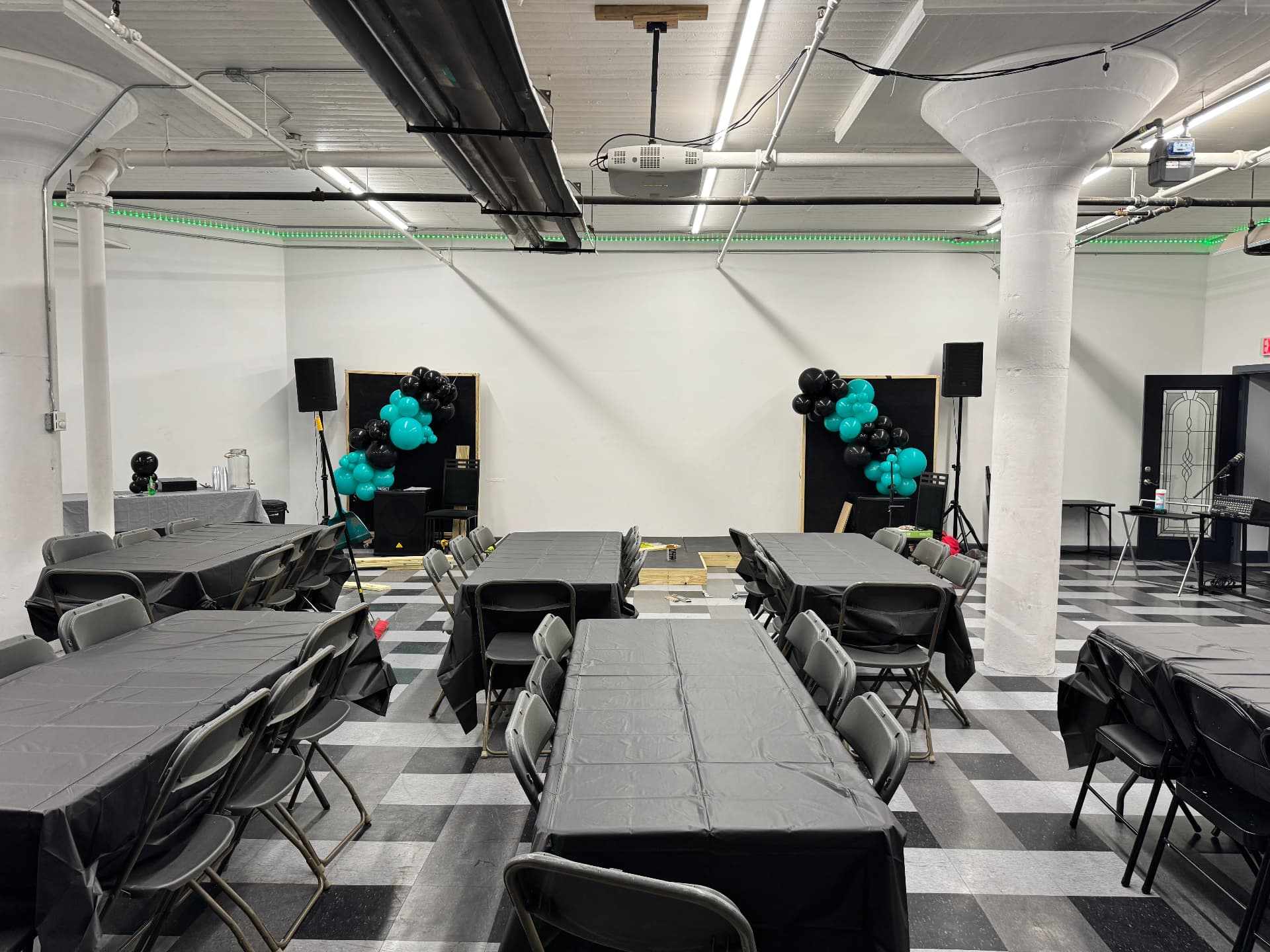 Event space set with round tables, black linens and balloon decor