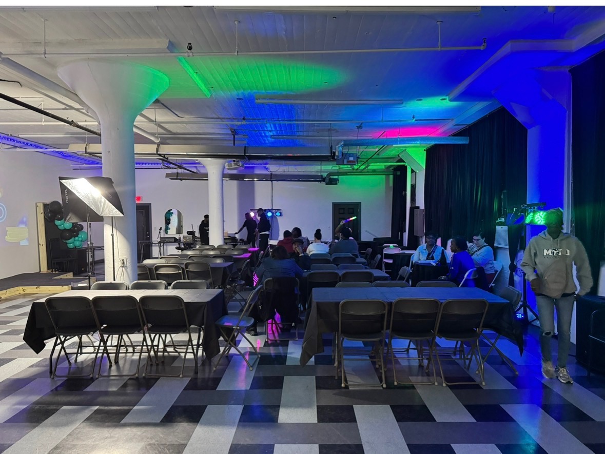 Guests at an event in the room with blue and green uplighting